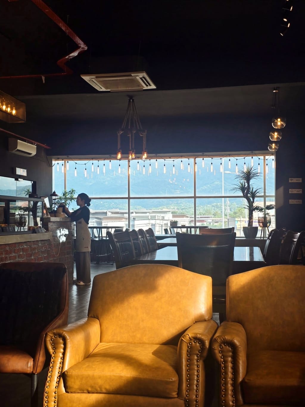 Warm evening light over The AnnEdible Cakery's dining room, mountains visible through floor-to-ceiling windows