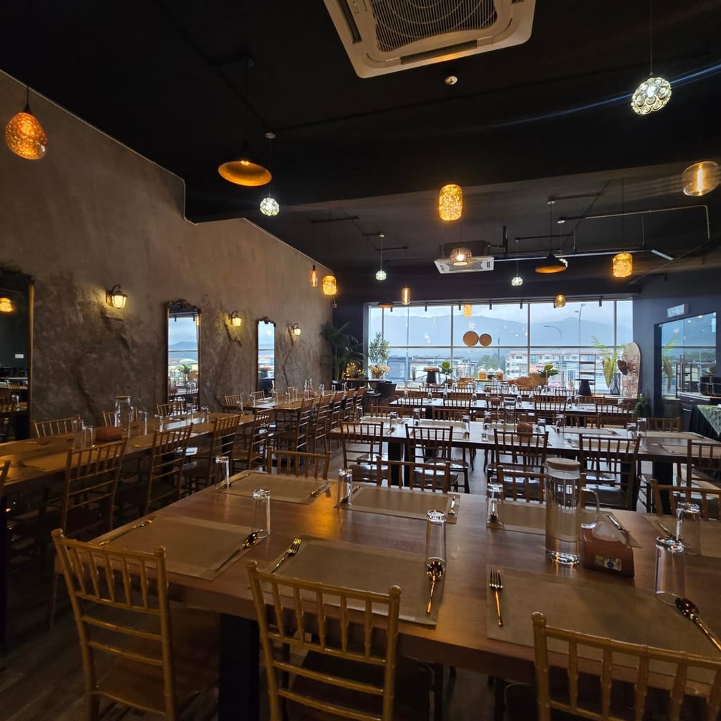 Wide view of the dining hall set with tables under warm pendant lighting