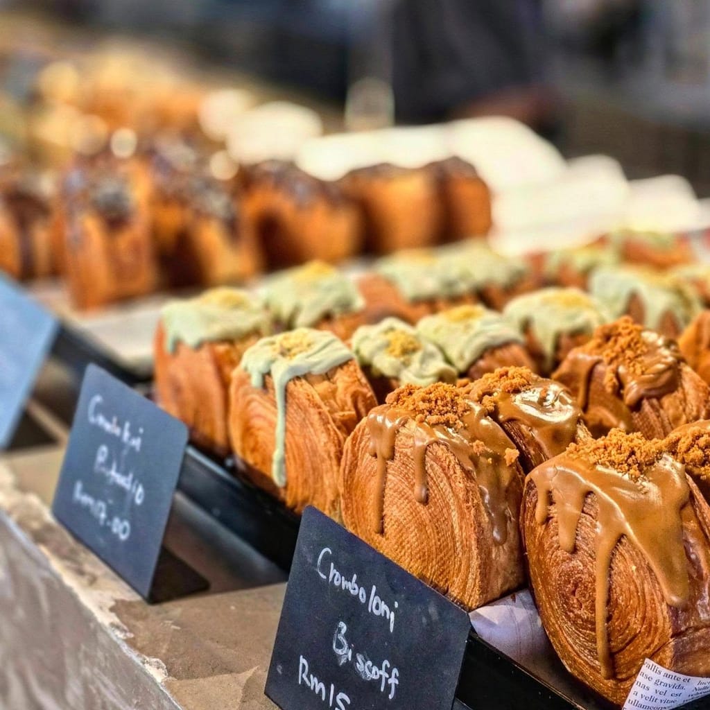 Cromboloni Pistachio and Biscoff in the display case with handwritten price cards