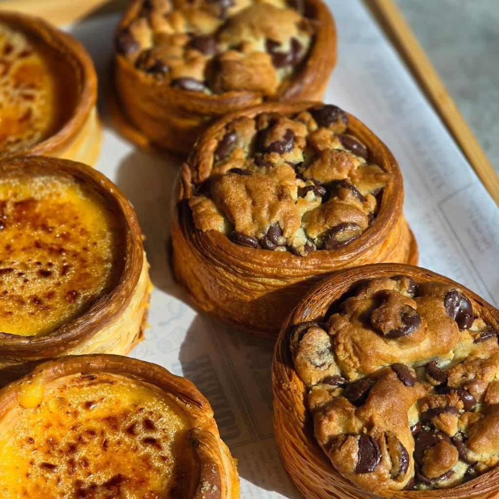 Crème brûlée croissant pods next to fresh baked croissants