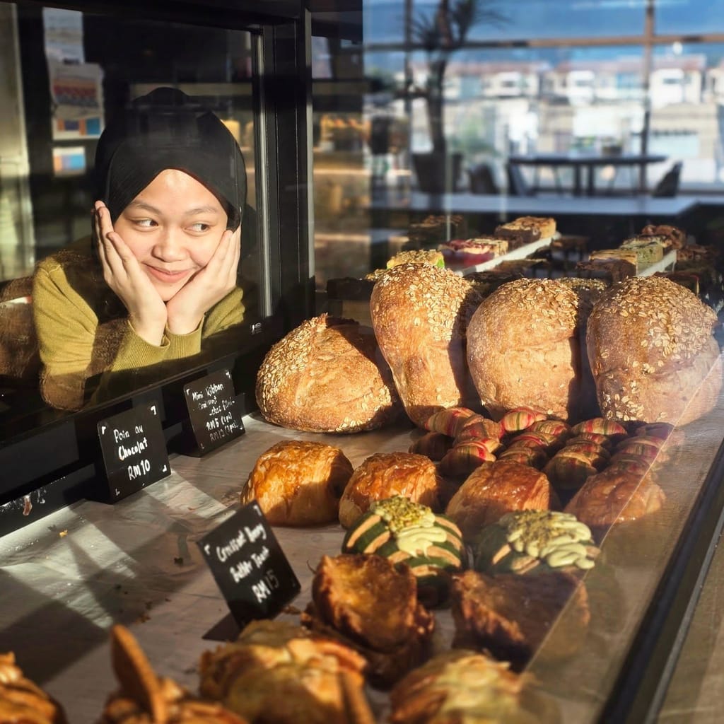 A team member peeking playfully through the bread display case