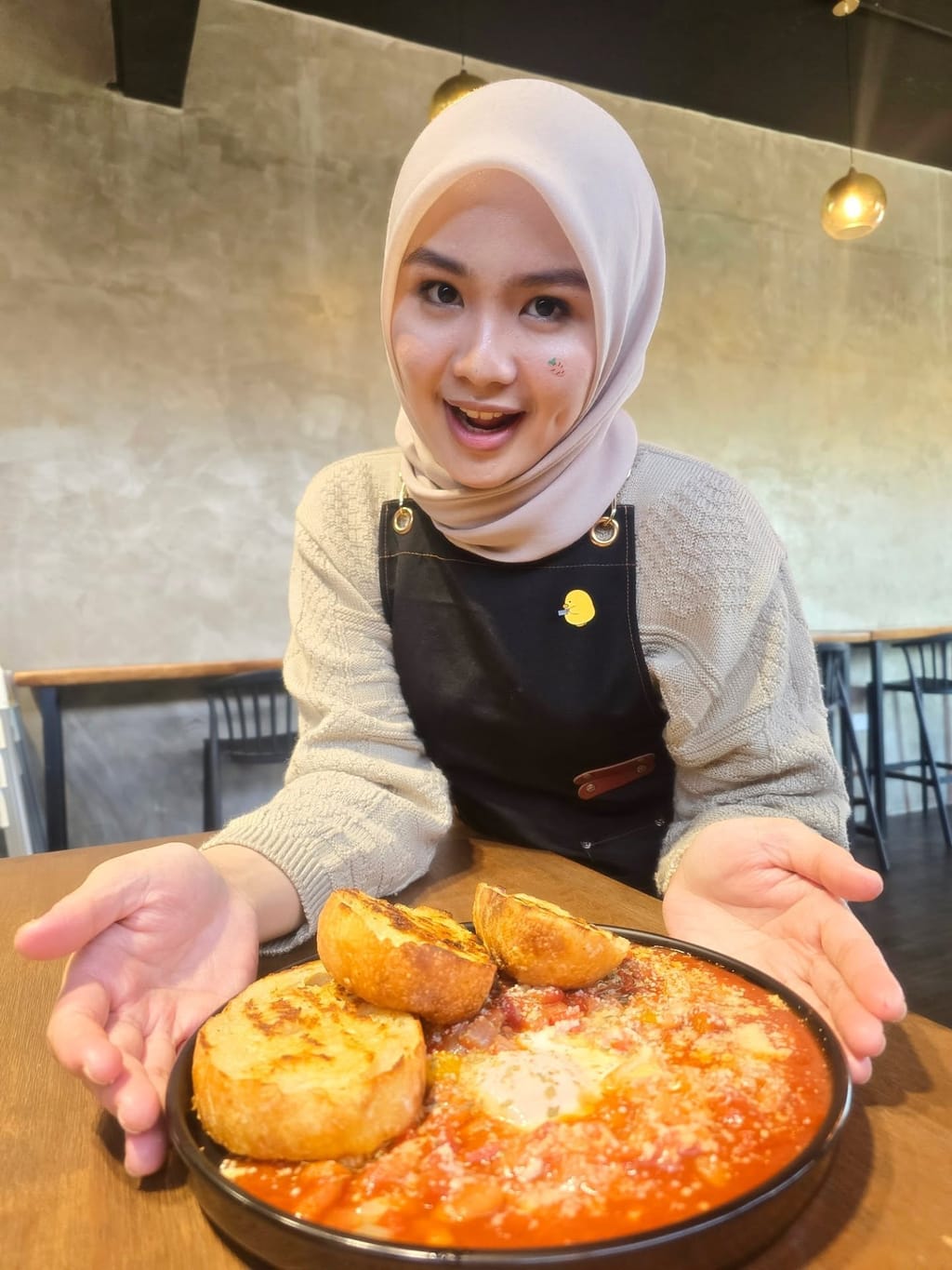 A team member presenting a shakshuka breakfast dish